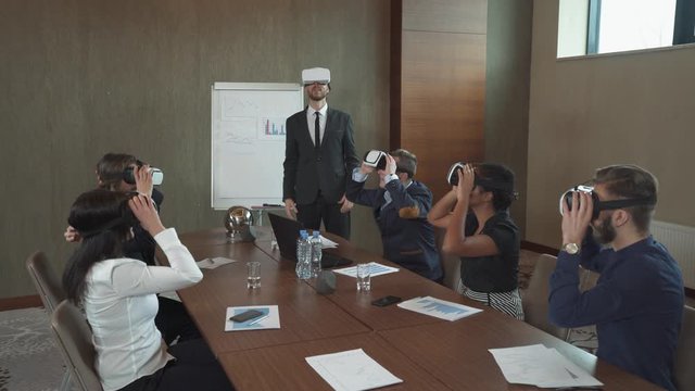 Modern business meeting, business people in virtual reality glasses, presentation using modern technologies, puts on virtual glasses.