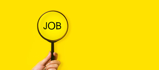 job search concept, inscription and magnifier in hand on a yellow background
