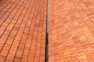 Two tiled rooftops with a rain gutter between them