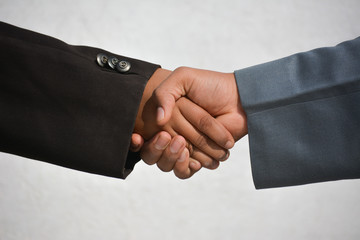 Business and office concept - Two confident business man shaking hands during a meeting