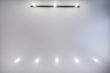 look up on suspended ceiling with halogen spots lamps and drywall construction in empty room in...