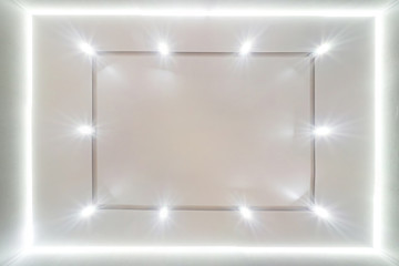 look up on suspended ceiling with halogen spots lamps and drywall construction in empty room in...