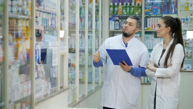Two young promoters makes a reconciliation of drugs in a pharmacy