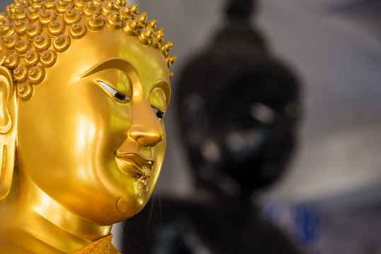 Close up gold Buddha face statue.