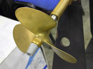 Three blades motor boat yellow bronze propeller stern drive close up