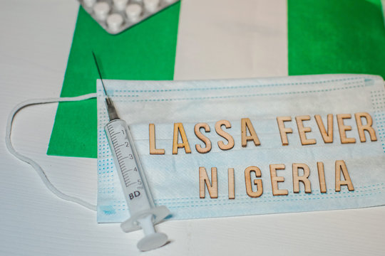 Nigerian flag under words Lassa fever outbreak concept. protective breathing mask and syringe. Lassa hemorrhagic fever LHF endemic in West Africa including Sierra Leone, Liberia, Guinea and Nigeria