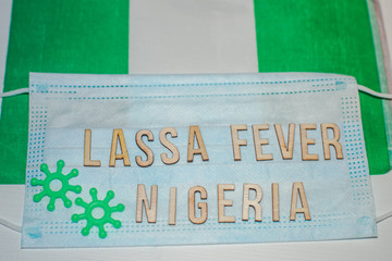 Nigerian flag under words Lassa fever outbreak concept. protective breathing mask and syringe. Lassa hemorrhagic fever LHF endemic in West Africa including Sierra Leone, Liberia, Guinea and Nigeria