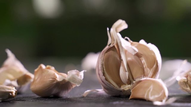 Whole garlic bulbs and garlic skin is blown away. Slow Motion.