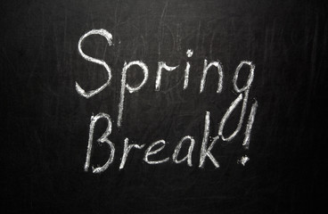 Spring break written in white chalk on a black chalkboard