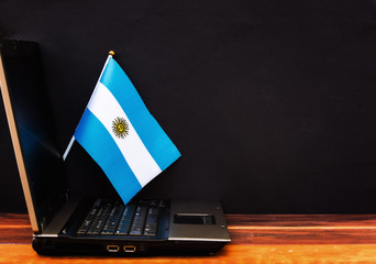  flag of Argentina , computer, laptop on table and dark background
