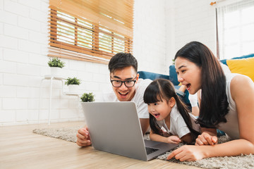 Asian family using laptop computer to surf internet / online shopping, happy family with technology...