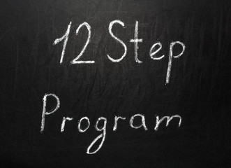 Twelve step program written in white chalk on a black chalkboard