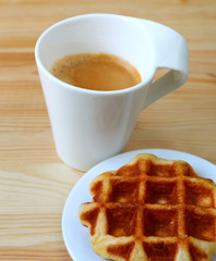 Plate of a Belgian Waffle with Blurry Hot Coffee in the Backdrop