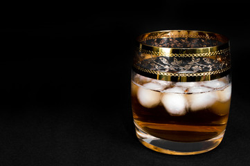 Glass of dark red whiskey, brandy or .bourbon with ice