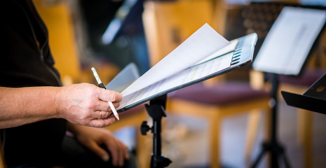 Hand und Noten bei Chorprobe mit Stift für Notizen, geringe schärfentiefe	