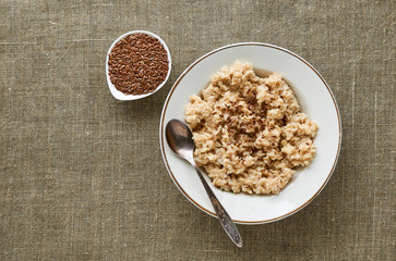 Oatmeal with flaxseeds on a textile background