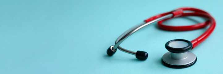 Red doctor stethoscope on blue modern background close-up. Medical insurance concept