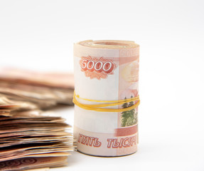 A pile of five-thousand-ruble bills and several banknotes twisted into a roll and tied with an elastic band.