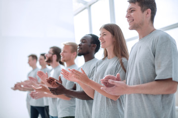 image a group of young people standing in a row applauding.