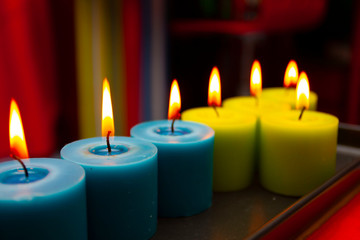 blue and green candles burning in a colored interior