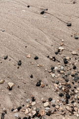 Different texture on the beach - water and sand, stones and pebbles, waves and splashes.