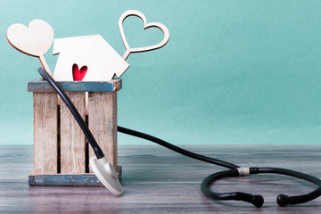 On the table is a wooden box wrapped with a statoscope. Three hearts protrude from the box.