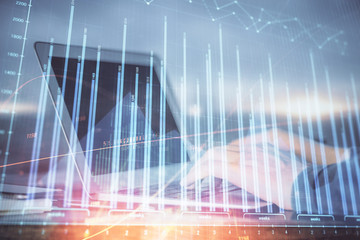 Double exposure of stock market graph with man working on laptop on background. Concept of financial analysis.