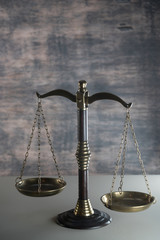 Law and Justice concept. Mallet of the judge, books, scales of justice. Gray stone background, reflections on the floor, place for typography. Courtroom theme.. Wooden rustic background