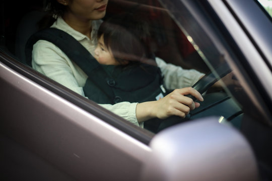 子供を抱っこしたまま運転する女性