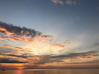 twilight sunset sky and crystal clear ocean surface with one yacht in the sea