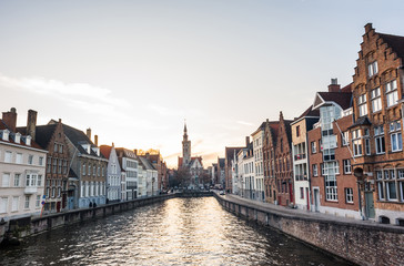 Fototapeta premium Charming street and canal at sunset in Bruges old town, Belgium. Popular travel destination and tourist attraction in Europe
