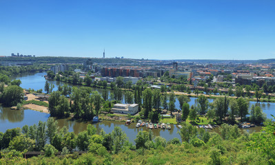 Fototapeta na wymiar Holesovice, district of Prague, capital of Czech Republic, Central Europe. Vltava river in foreground surrounded by riverside residential neighborhood area.