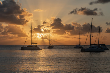 Sunset view of yachts and catamarans anchored in the lagoon, Britannia bay, Mustique island, Saint...