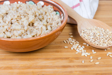 Pearl barley porridge and uncooked pearl barley groats, fragment closeup