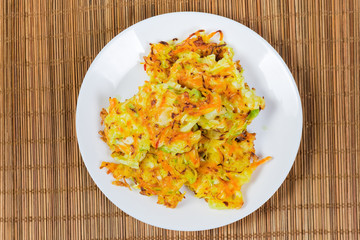 Top view of savory cabbage pancakes on white dish