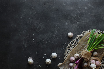 Obraz na płótnie Canvas purple spring onions on dark table background