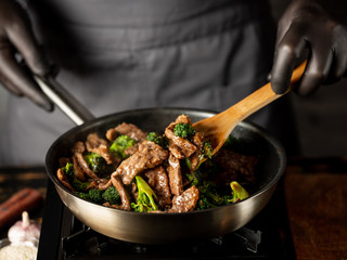 Beef with broccoli vegetables cooking roasting in steel pan.