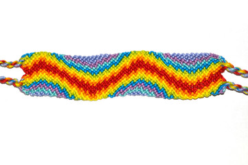 Bright wavy friendship bracelet handmade of threads isolated on white background