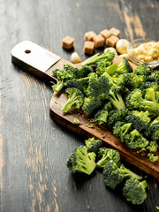 Fresh healthy broccoli vegetables cutting on wooden desk. Close up. Cooking vegetarian recipe concept.