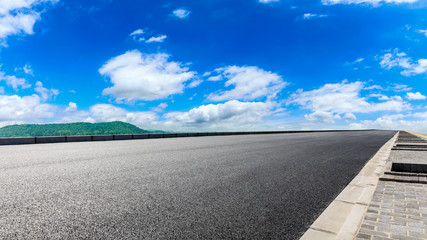 Empty asphalt road and green hill with beautiful sky clouds.