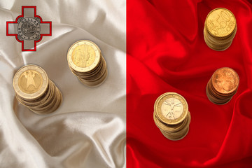 metal currency coins on the background of the national flag of the country of Malta, the concept of...