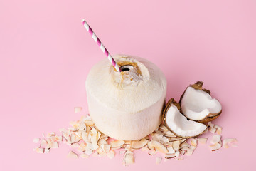 Young coconut with straw on color background