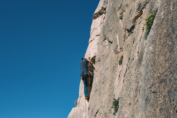 Fototapeta premium Rock climber in Spanish mountains with blue sky.