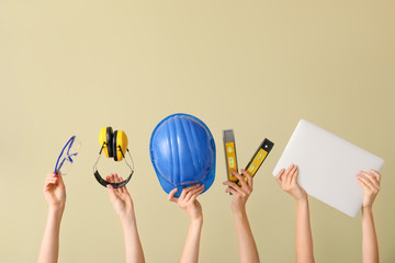 Fototapeta premium Many hands with architect's supplies and laptop on color background