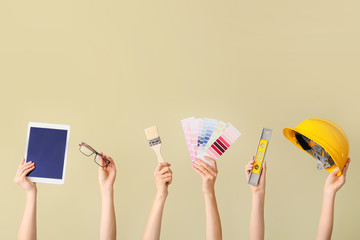 Many hands with architect's supplies and tablet computer on color background