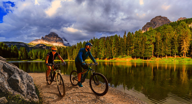 Cycling outdoor adventure in Dolomites. Cycling woman and man on electric mountain bikes in Dolomites landscape. Couple cycling MTB enduro trail track. Outdoor sport activity. © Gorilla