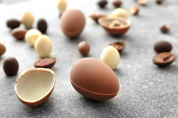 Tasty chocolate Easter eggs on grey background