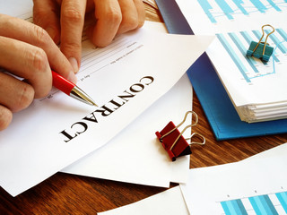 Businessman reads contract in the office for signing.