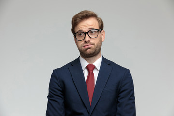 businessman standing and holding air in his mouth anxious