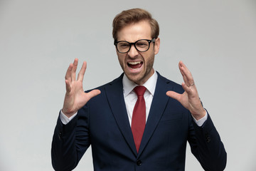 businessman standing with hands up and looking away angry